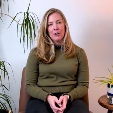 Cate Evans, a woman with shoulder-length wavy blonde hair, seated in a calm consulting room